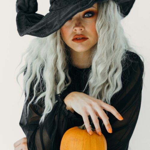 Woman in Black Witch Costume With Two Pumpkins