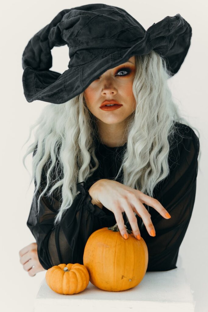 Woman in Black Witch Costume With Two Pumpkins