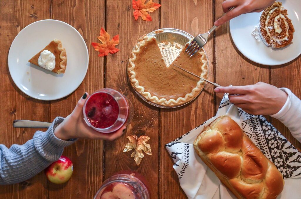 Slicing of Pumpkin Pie Placed on Wooden Surface