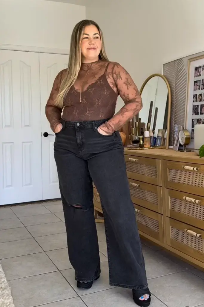 midsize woman wearing chic Thanksgiving outfit with a brown lace long sleeve top, lace bodysuit and dark wide leg jeans