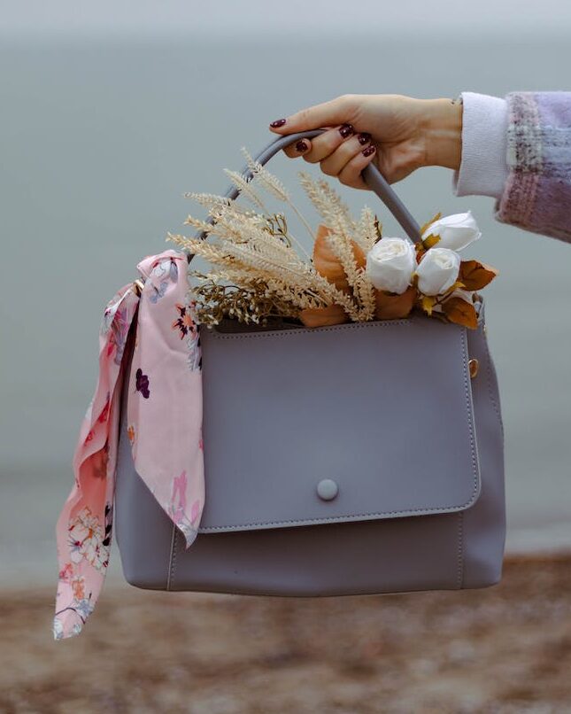 Hand Holding Handbag with Bouquet Inside