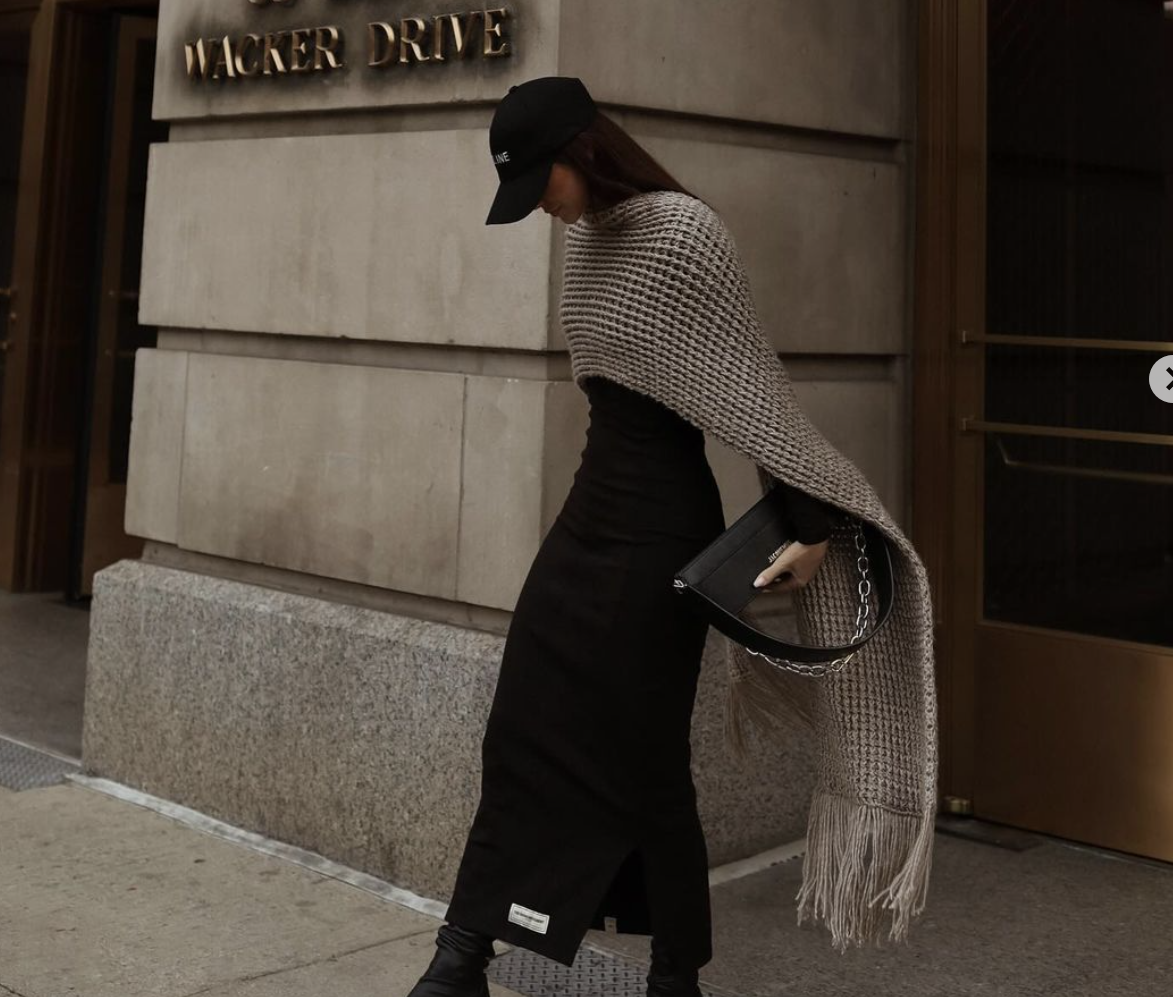 woman outside store wearing large scarf