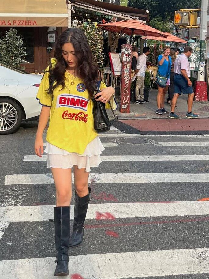 young woman wearing aesthetic fall streetwear jersey and ruffle skirt