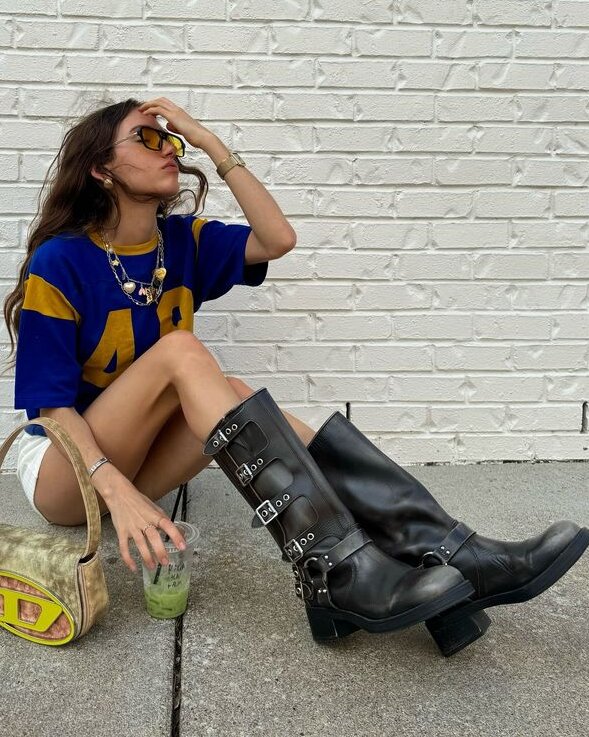 girl on ground wearing jersey and moto boots