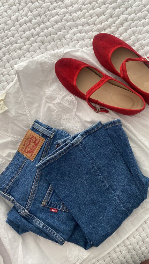 jeans, red ballet flats and white top laid out