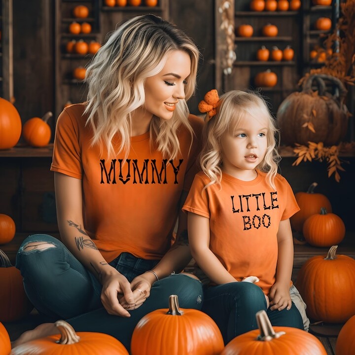 young blonde mom and young daughter in matching Halloween shirts