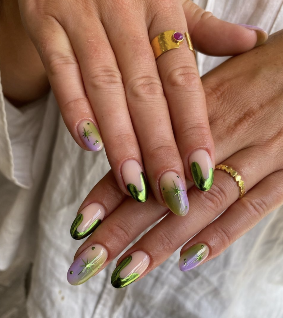 green and purple celestial nail art done on female hands