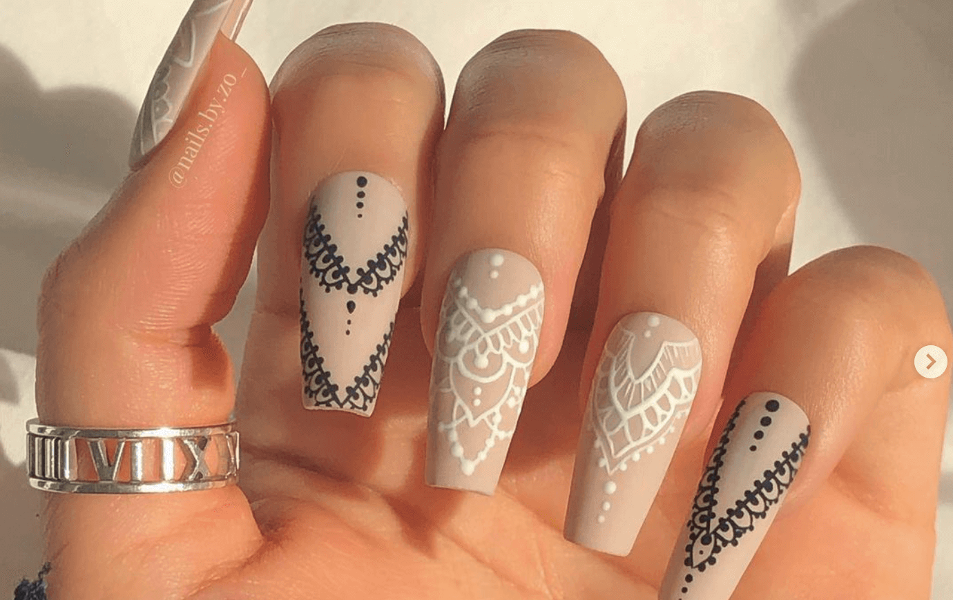 elegant Halloween nail art featuring black and white lace design