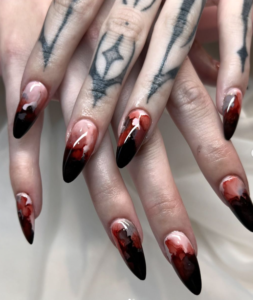 female spooky nail set with swirling red polish