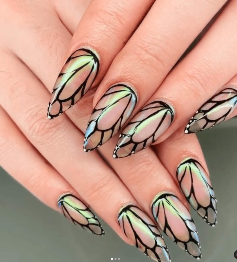 butterfly wing nail art with black lines and green iridescent gloss over