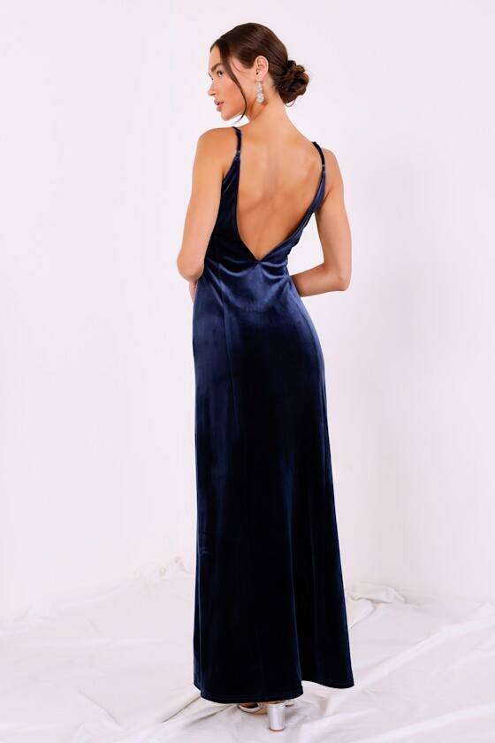 model wearing navy blue velvet deep back dress