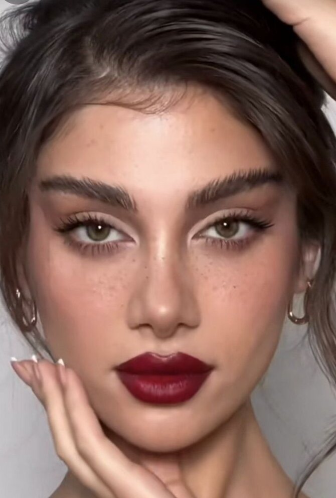 close up of young woman with soft eye makeup and a bold dark red lip