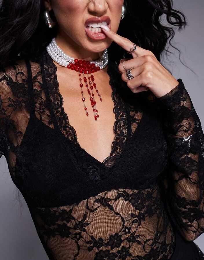 picture of model wearing pearl necklace with red drip beading mimic of blood drops