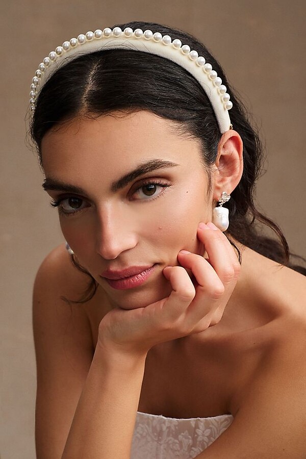 young dark hair model wearing pearl drop earrings and a pearl embellished headband