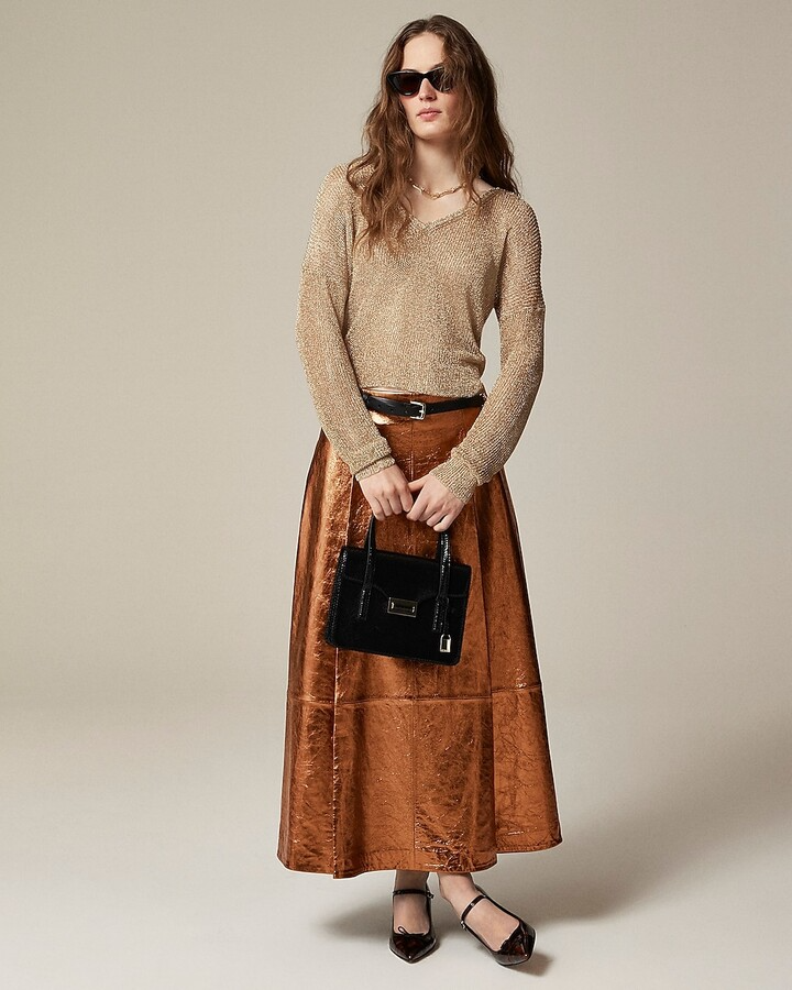 model wearing metallic copper a-line maxi skirt with cream sweater