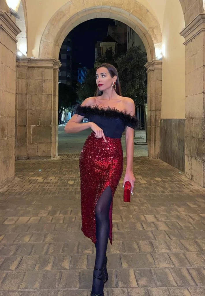 woman standing in arch way wearing formal Christmas outfit