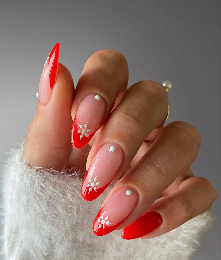 red french tip nails with pearl accent and snowflake design