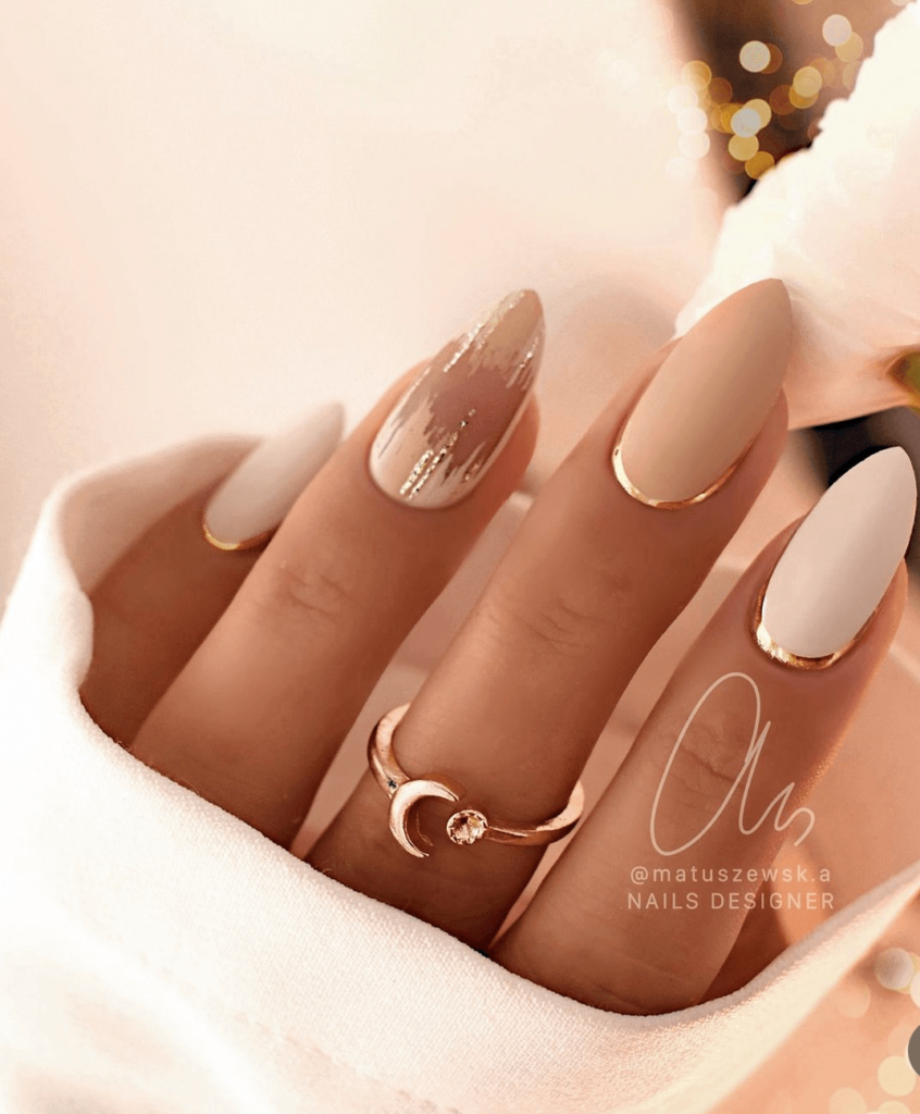 Geometric white and neutral nail art with gold accents