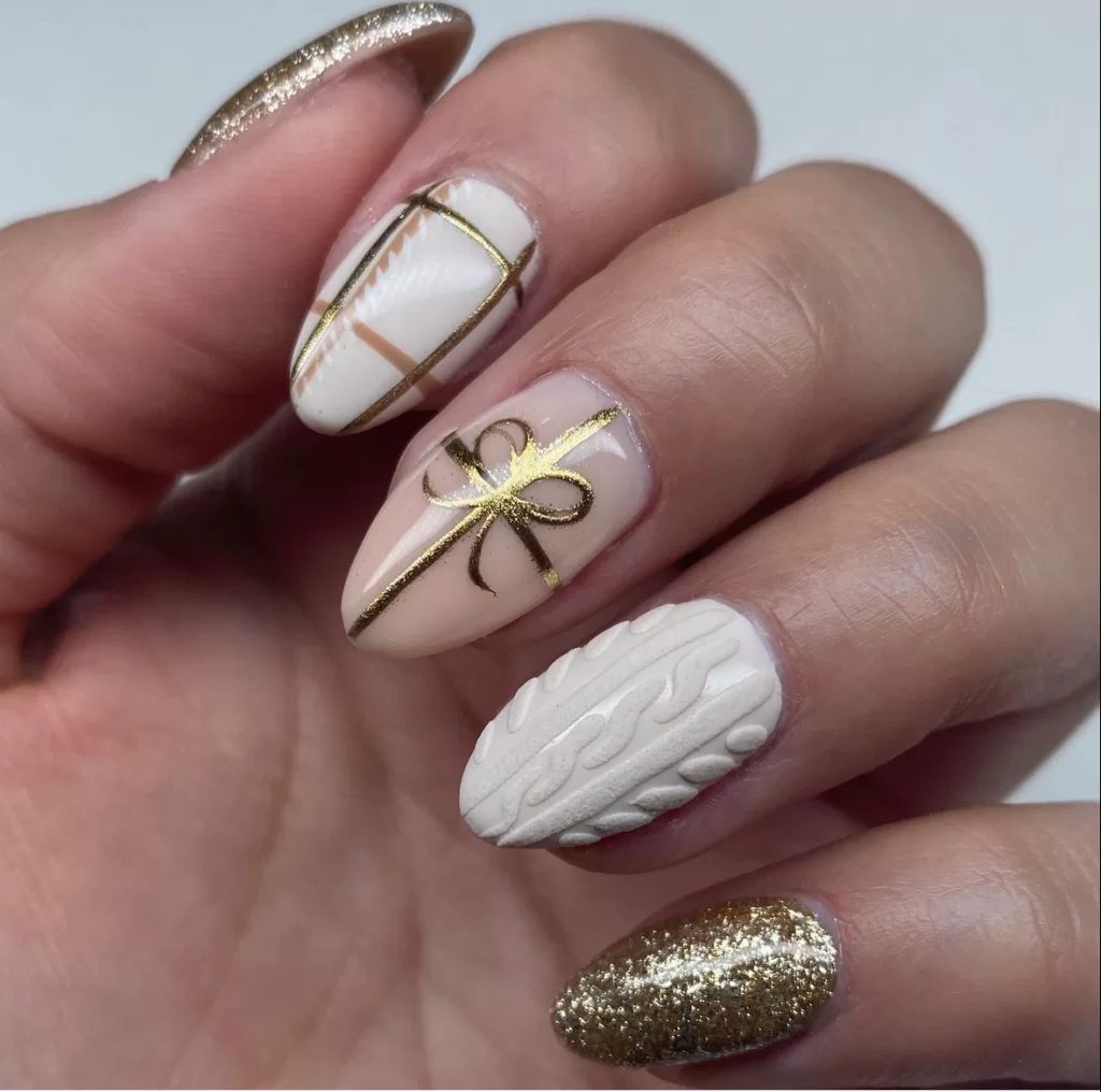 Christmas motif nails with gold present accents on white nails