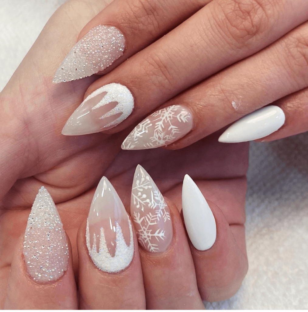 white dramatic winter nail art with icy designs and pearl accents