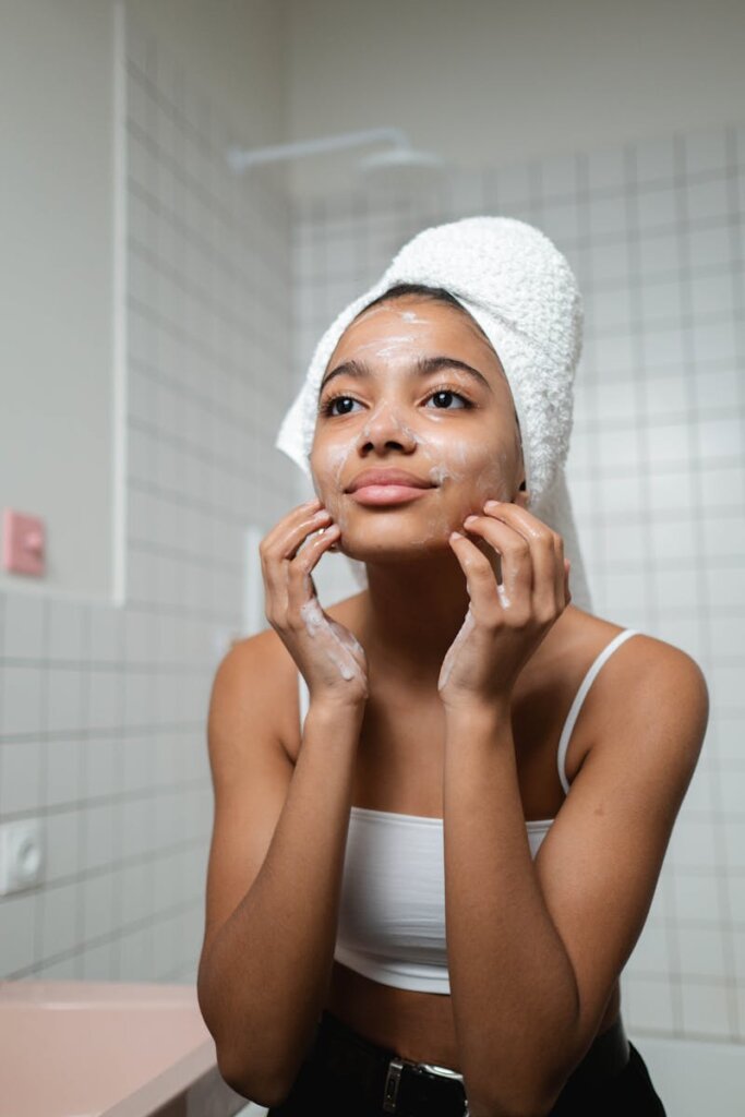 A woman applying skincare in a modern bathroom, embracing a healthy lifestyle.