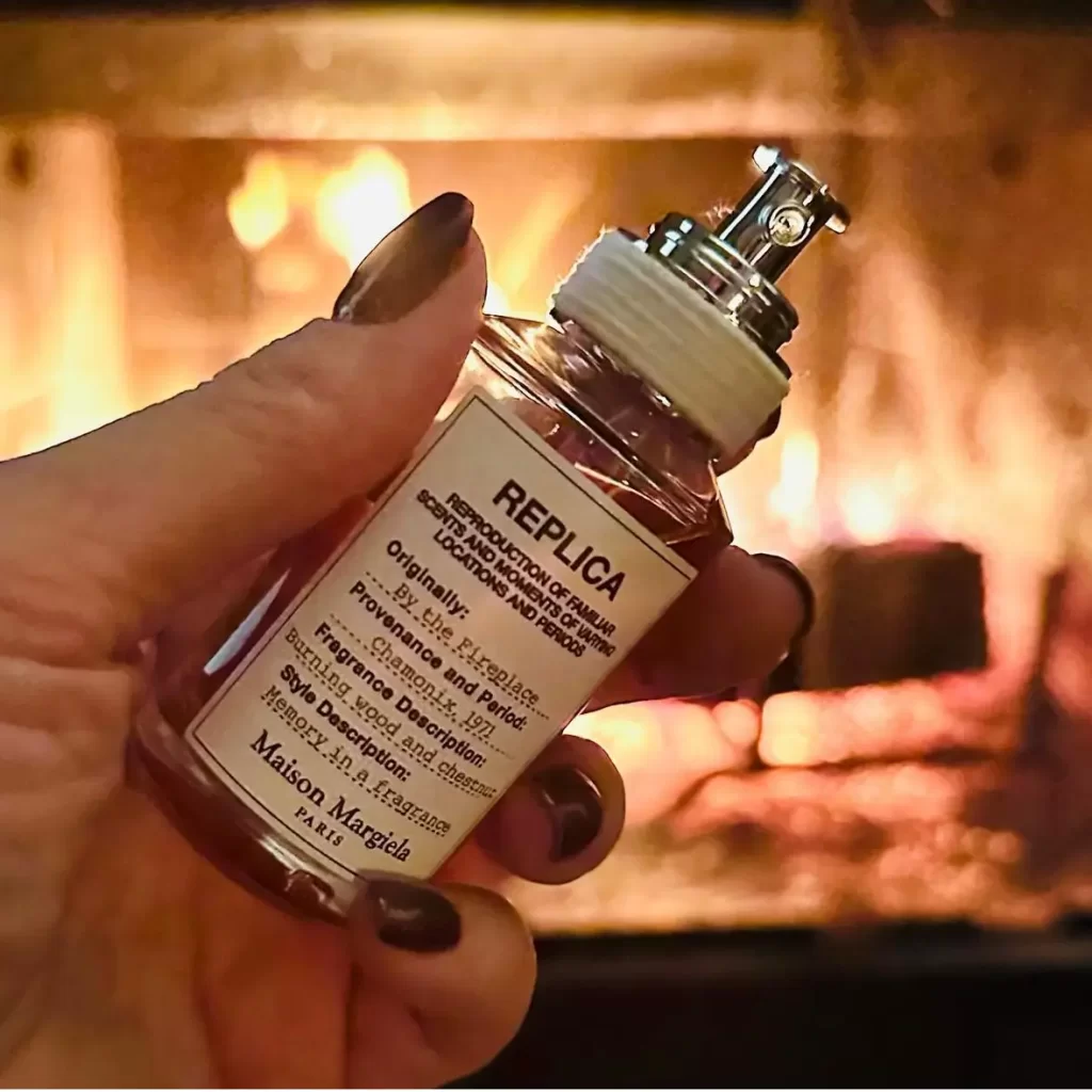 Replica By The Fire perfume held up against a roaring fire