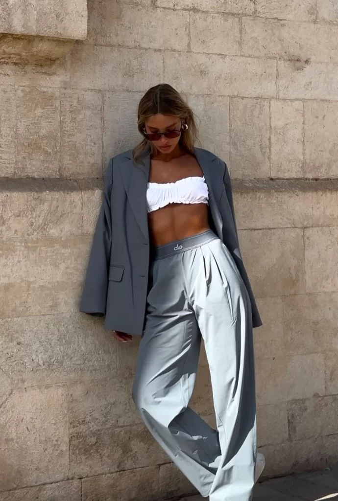 Influencer wearing grey sweatpants with matching grey blazer and white bra top