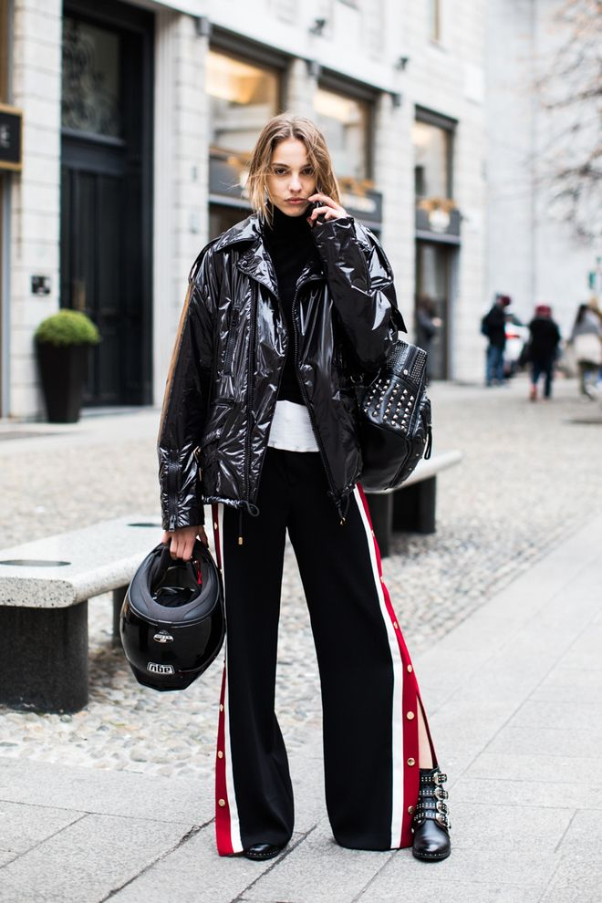 young blond woman wearing baddie sweatpants outfit with black leather jacket and black boots