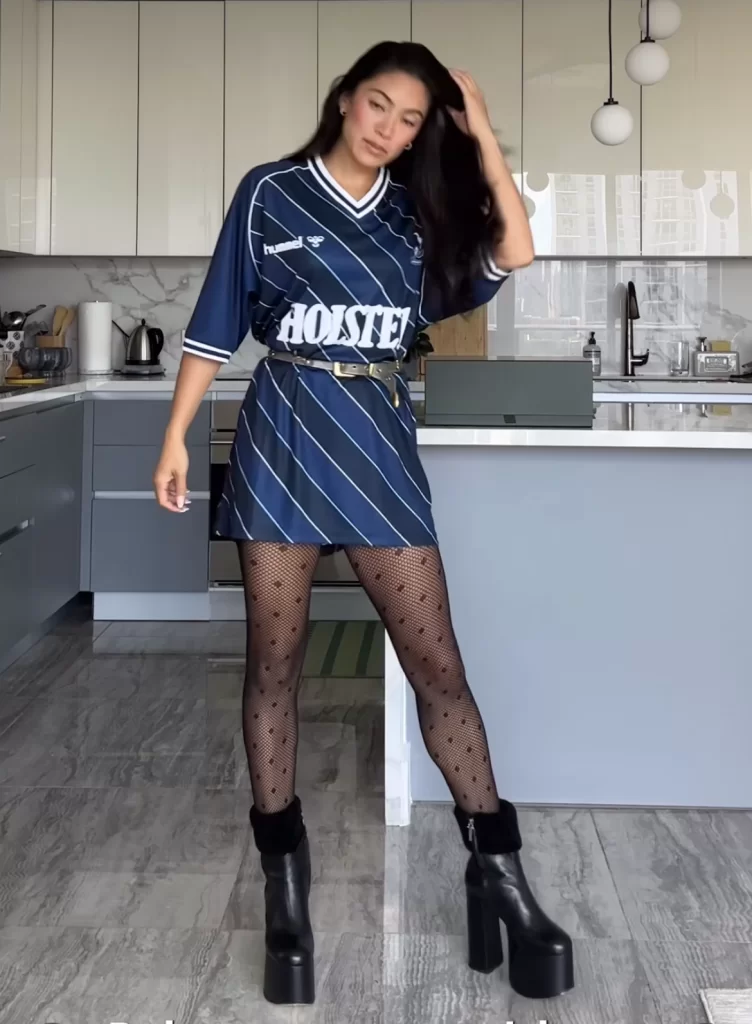 Sports influencer showing how to belt oversized jersey into a dress