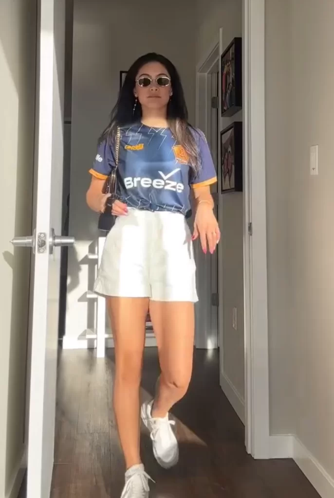 Sports caster Jenny Achiu wearing warm weather game day outfit with jersey and shorts