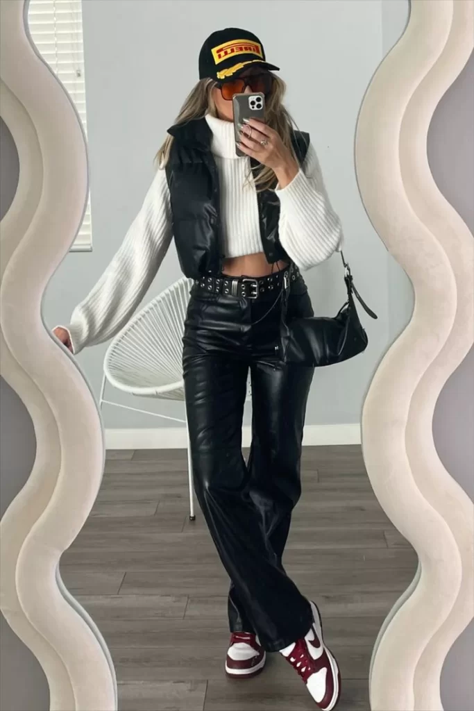 young woman wearing leather on leather game day outfit with black trucker hat and cropped hoodie