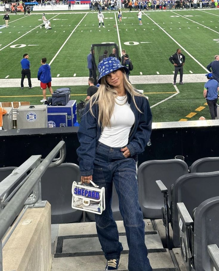 young blonde woman wearing dark denim outfit with team logo bucket hat