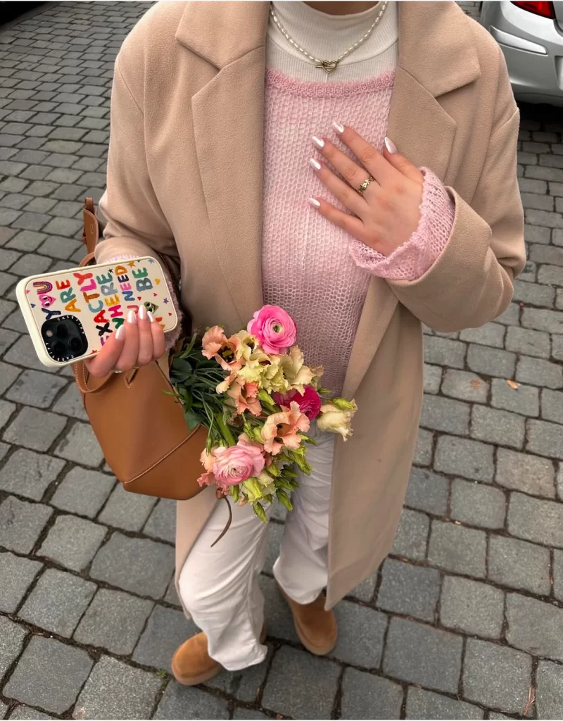 close up of a cute Valentine's Day casual outfit with pink sweater and tan coat