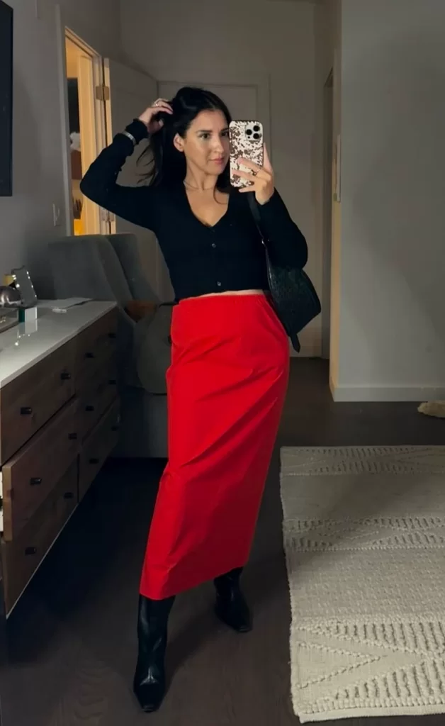 Influencer wearing black long sleeve top and bright red satin maxi skirt