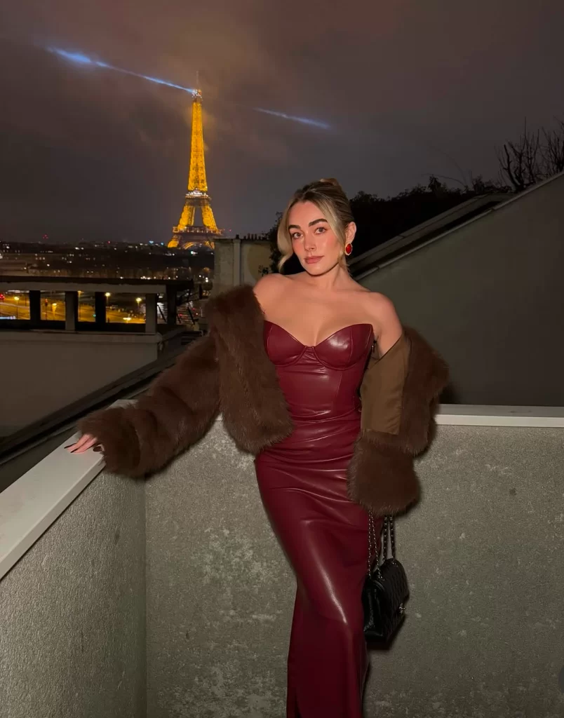 young woman posing at night in front of Effiel Tower wearing dark red leather dress and fur coat Valentines day outfit winter ideas