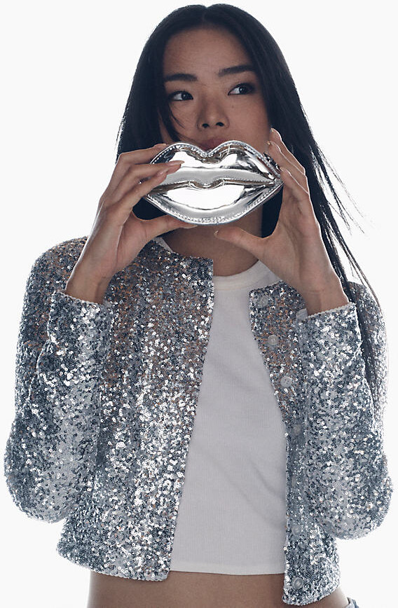 model holding up sliver lips purse over mouth