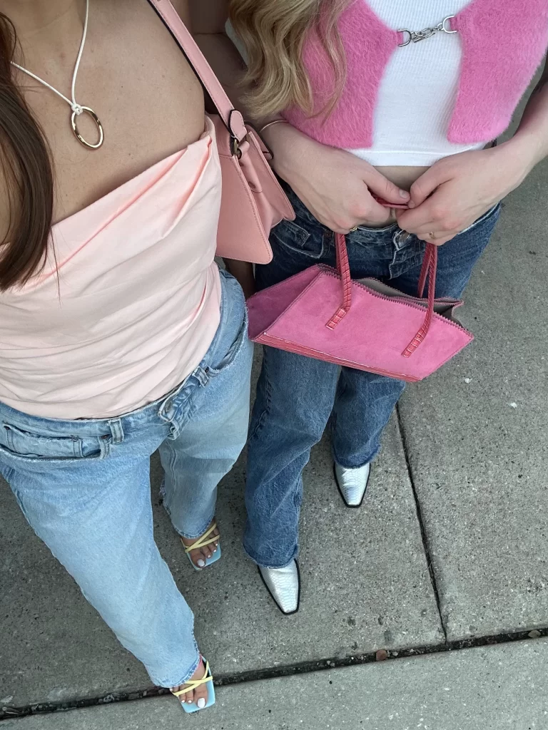 close up cropped photo of two girls wearing pink tops with jeans as a casual Valentine's day outfit