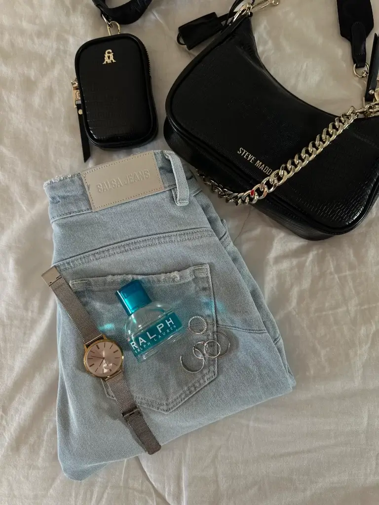 best spring perfume bottle laid out with jeans and accessories