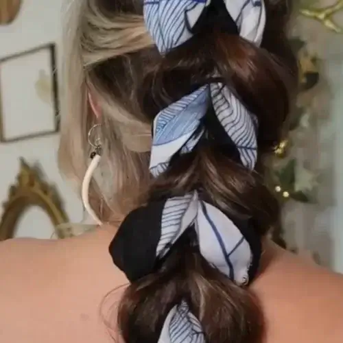 woman's braided hairstyle with blue silk scarf woven in