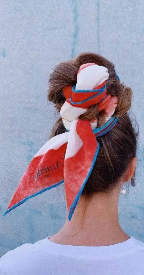 woman showing the back of her hair tied up in intricate knots with color scarf