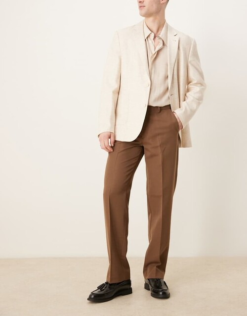 male model wearing light color blazer and button down shirt with darker brown chinos and brown dress shoes as a graduation outfit