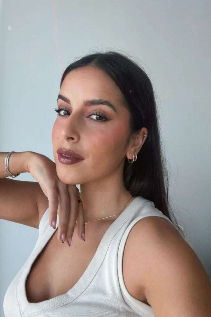 Young woman with dark hair wearing a darker latte tone inspired makeup look for Fall