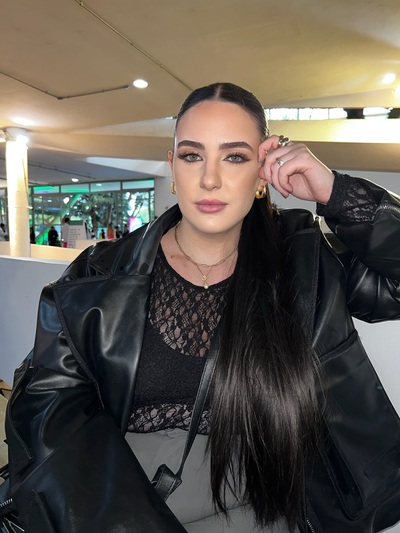 woman sitting in restaurant with long dark hair slicked back into a neat ponytail