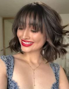 A young woman getting ready for a date night and showing off how she styles her shorter pixie cute with tousled waves