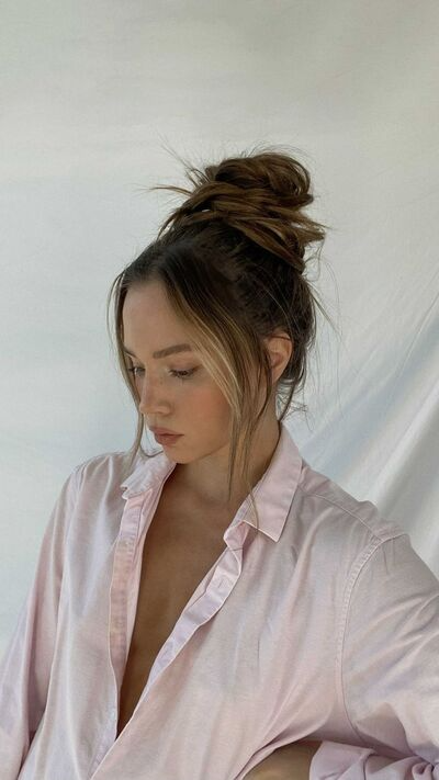 Young woman showing off her messy top knot hairstyle