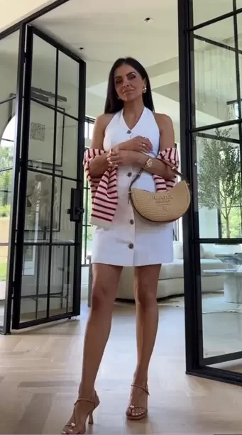 woman carrying a striped cardigan over her white mini dress for a night out summer look