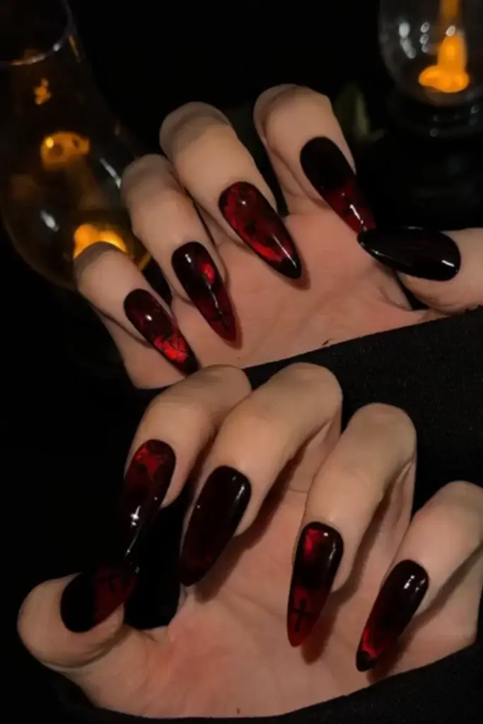 dark black and red edgy nail design on elongated stiletto nails