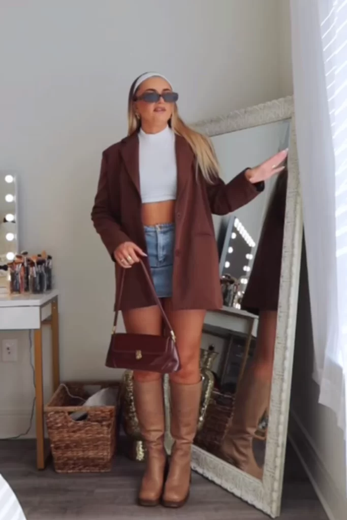 woman standing in front of mirror wearing fall outfit that works for hot climate