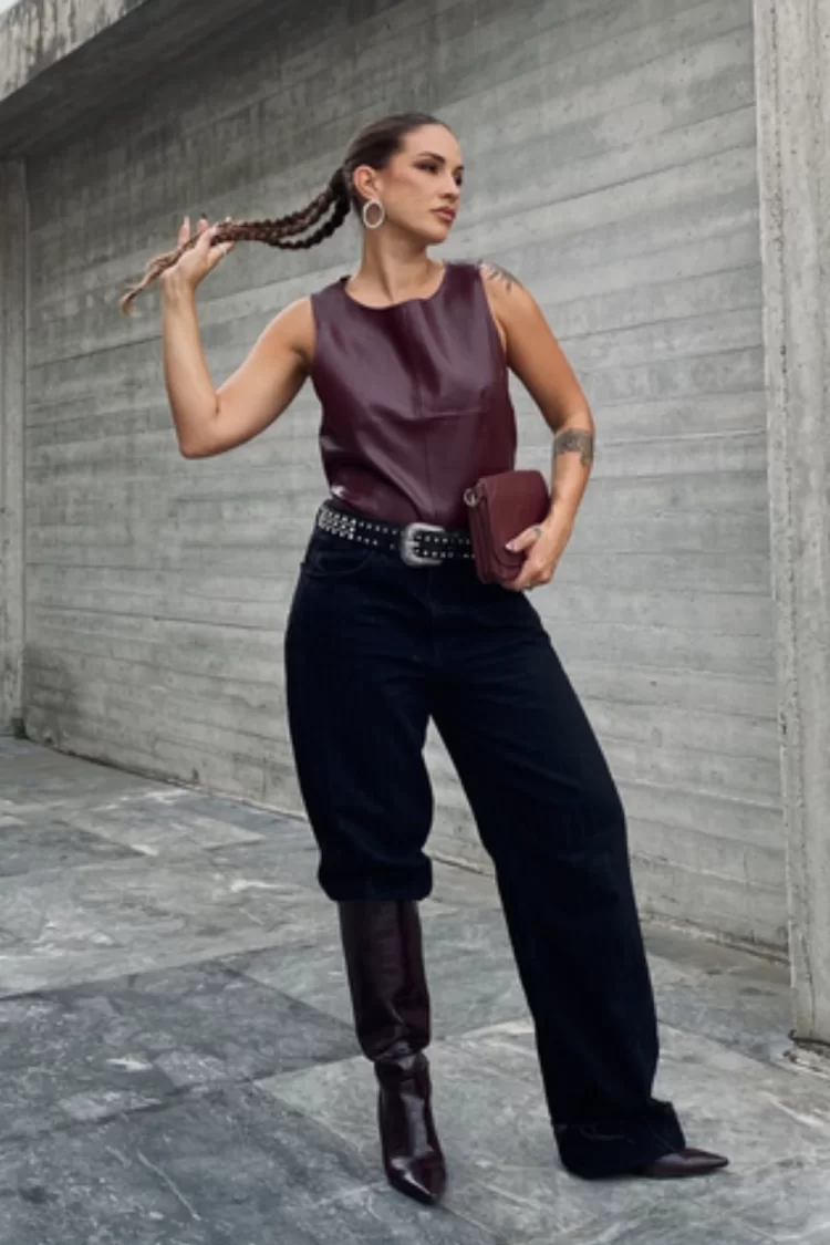 Knee-high boots worn under and over baggy jeans, demonstrating 2025’s top trend for fall and winter denim looks