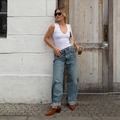 model wearing cuffed medium wash boyfriend jeans with brown suede heeled clogs